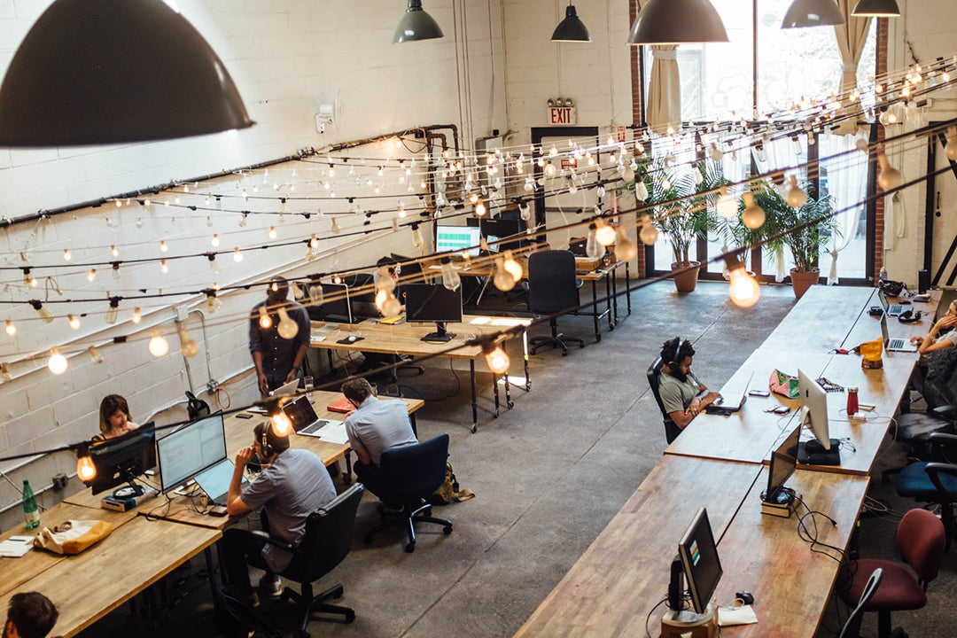 People working in an open space corporate setting on their laptops