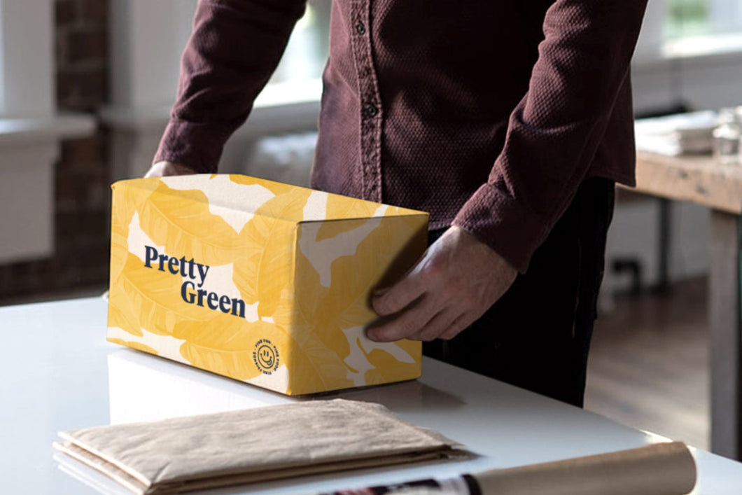 Person preparing to open Pretty Green yellow gift box to put sustainably wrapped Australian products in
