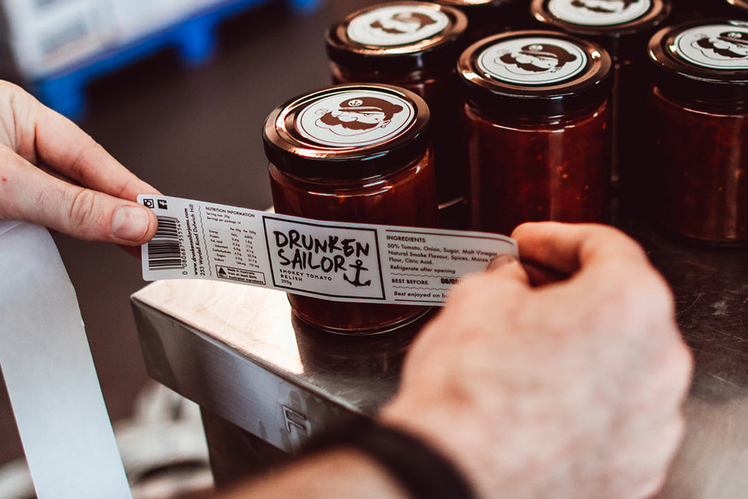 Justin from Drunken Sailor Canning Co labelling his smokey tomato relish